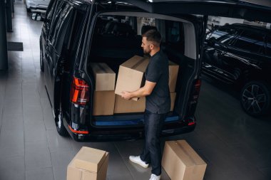 Kutuları boşaltıyorum. Teslimatçı ya da yükleyici arabanın yanında..