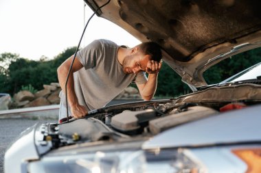 Bozuk otomobili tamir etmeye çalışıyorum. Adam dışarıda arabasıyla bekliyor..
