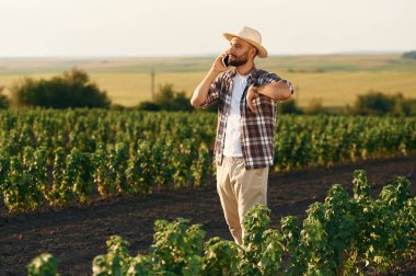 Telefonla konuşuyorlar. Çiftçi tarım alanında..