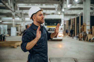 Eller hareket eder, aracı park etmeye yardım eder. Erkek işçi, modern depo veya imalat şirketinde çalışıyor..