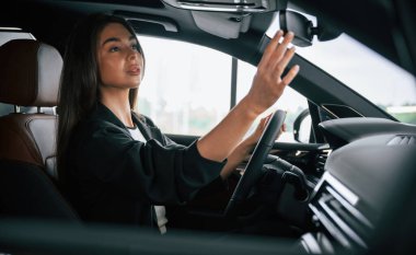 İçerisi rahattır. Güzel iş kadını yeni arabasında..