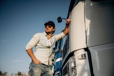 Ön manzara, kabine yaslanma. Kamyon şoförü açık havada nakliye aracının yanında..