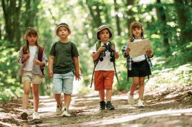 Birlikte yürüyoruz. Yazın ormanda çocuklar.