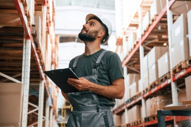 Not defteri kullanıyor. Foreman depoda, kargo dağıtım işinde..