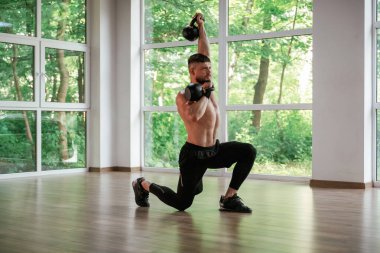 Ağır halterlerle. Güçlü kaslı adam spor salonunda çalışıyor..