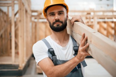 Ön manzara, kalas tutuyor. Ahşap depoda sanayi işçisi..