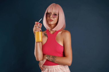 Güzel pembe saçlar. Portakal suyuyla. Güzel genç bayan arka plana karşı..