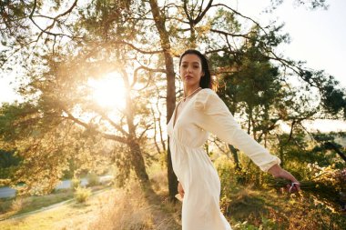 Güneş ışığına karşı. Doğada bir buket çiçekle bir kadın..