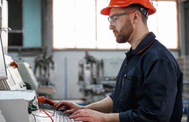 Makineyi çalıştırıyorum. Fabrika işçisi kasketli bir şekilde içeride..