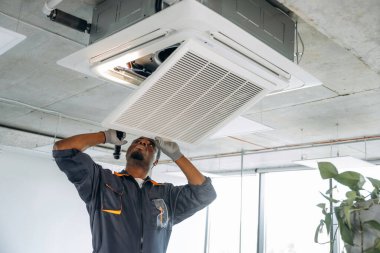 Havalandırmayı tamir ediyorum. Tamirci modern ofiste kapalı bir yerde..