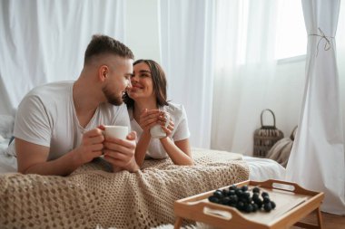 İnsanların önünde üzümlü küçük bir masa. Genç çift evde birlikteler..