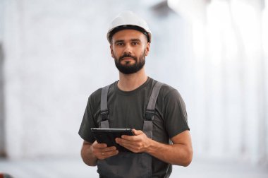 Güzel bir portre. Erkek işçi boş depoda..