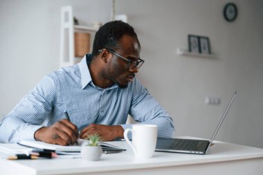 Evrak işleriyle uğraşıyorum. İşadamı laptopla ofiste..