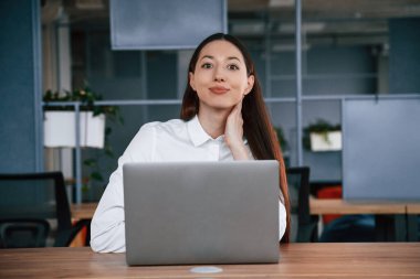 Dizüstü bilgisayarla çalışıyor. İş kadını ofisin içinde..