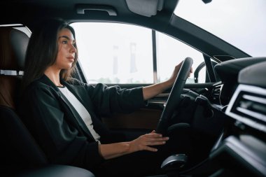 Yandan bak. Güzel iş kadını yeni arabasında..