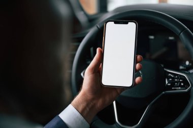 Ekranda kopya alanı olan akıllı telefon. İşadamı yeni arabasında..