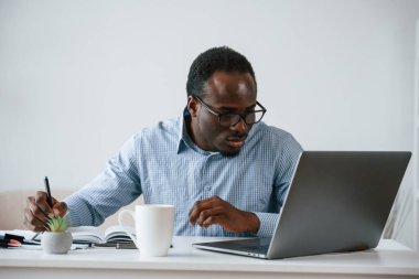 Müdür dizüstü bilgisayar kullanıyor. İşadamı ofiste çalışıyor..