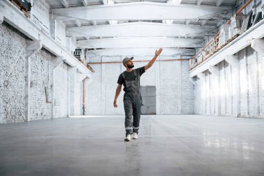 Büyük bir alan. Erkek işçi boş depoda..