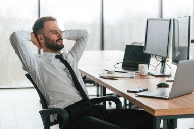 İşadamı bilgisayar başında oturuyor ve ofiste çalışıyor..