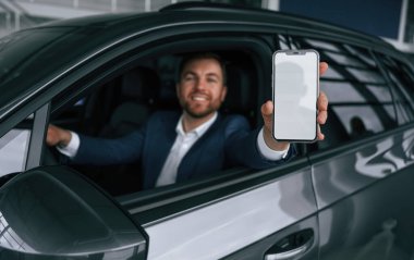 Ekranda kopya alanı olan akıllı telefon. İşadamı yeni arabasında..