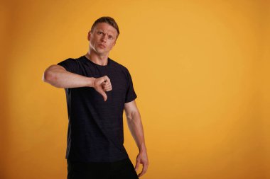 Tatmin olmamış, hoşnutsuzluk gösteriyor. Adam stüdyoda arka plana karşı..