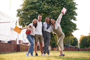 Poz vermek ve gülümsemek. Bir grup öğrenci birlikte dışarı çıktılar..