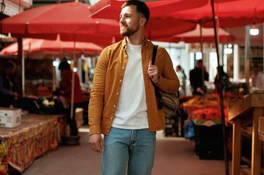 Ön manzara, yürüyüş. Yakışıklı adam sokak pazarında ya da pazarda..