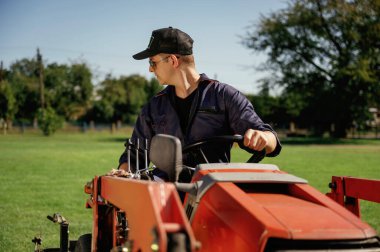 Ön manzara, çalışma, sürüş. İnsan, çim biçme makinesi ve havacılık ekipmanlarıyla birlikte arazi aracında..