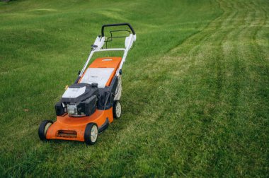 Çim biçme makinesi gündüz vakti yeşil çimlerin üzerinde..