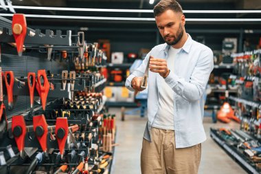 Baltayı karıştırmak. Adam hırdavatçıda..