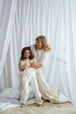 Yatakta ayakta durup oyun oynuyorlardı. Anne ve kızı evde birlikteler..