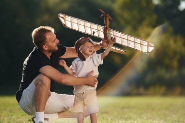 Hafta sonu aktiviteleri. Baba ve oğul oyuncak uçakla sahadalar..