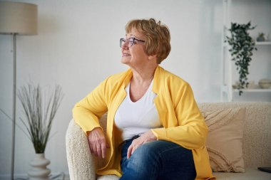 Sıcak bir kanepede. Yaşlı yaşlı kadın evde, oturma odasında..