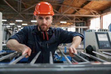 Endüstriyel hat çalışıyor. Fabrika işçisi kasketli bir şekilde içeride..