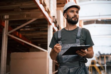 Not defteri kullanıyor. Foreman depoda, kargo dağıtım işinde..