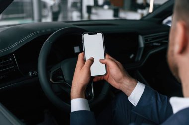 Ekranda kopya alanı olan akıllı telefon. İşadamı yeni arabasında..