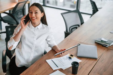 Telefonla konuşarak. İş kadını ofisin içinde..