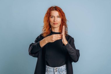 İşaret dili, harfleri gösteriyor. Kadın stüdyoda arka planda..