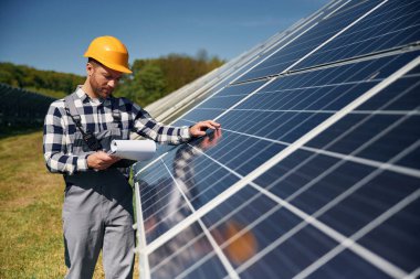 Yüzeyi kontrol ediyorum. Gündüz vakti fotovoltaik güneş panelleri olan bir mühendis..