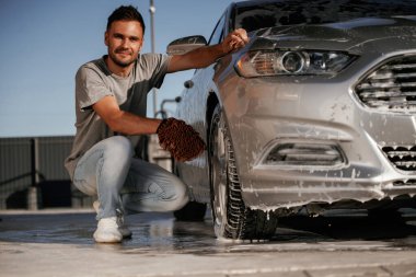 Oturup otomobili yıkıyorum. Adam dışarıda arabasıyla bekliyor..