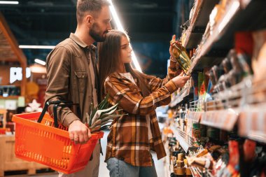 Ellerinde yağ var. Genç çift süpermarkette beraberler..