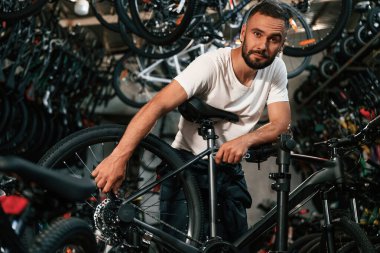 Tekerleği ayarlıyorum. Bisiklet dükkanında tamirci, mağazada çalışıyor..