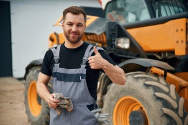 Elleri temizleyecek kumaşla iyi iş çıkardın. Adam traktörle birlikte. Tarım işçisi.