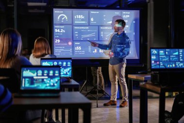 Grafik yükseliyor. Erkek işletme eğitmeni projektöre karşı, insanlara öğretiyor..