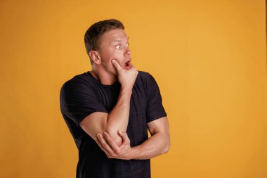 Korkmuş, stresli hissediyorum. Adam stüdyoda arka plana karşı..