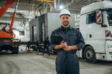 Ön manzara, ayakta. Erkek işçi, modern depo veya imalat şirketinde çalışıyor..