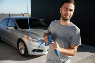 Araba yıkama işi. Adam dışarıda otomobille geziyor..