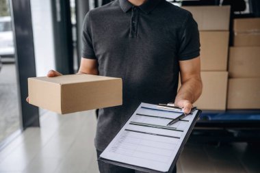 Not defterindeki veriler. Teslimatçı ya da yükleyici elinde bir kutuyla arabanın yanında..