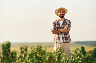 Kollarını kavuşturarak. Çiftçi tarım alanında..