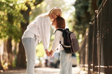Annesiyle okul kızı dışarıda beraberler..